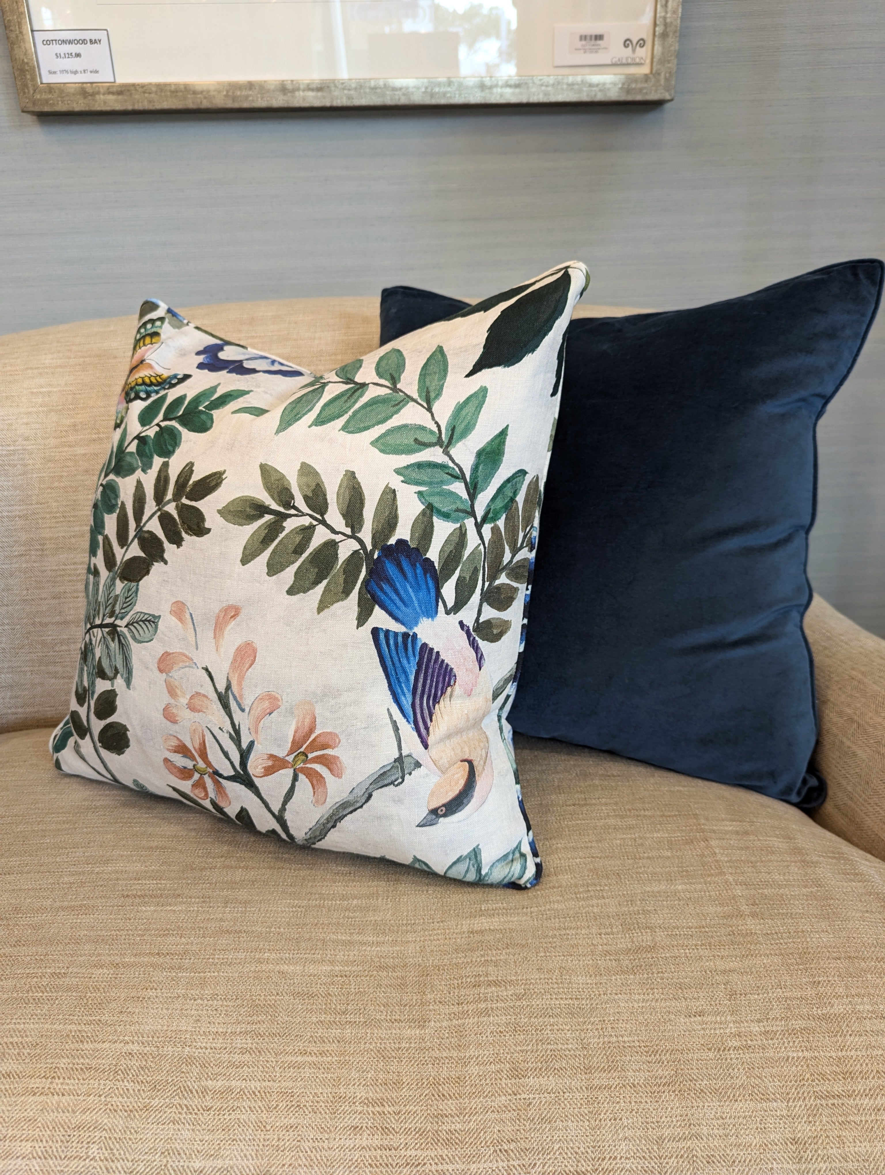 Designers Guild Porcelaine De Chine Cushion placed on sofa next to a navy blue cushion.